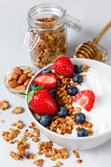 Homemade oatmeal granola bowl with greek yogurt, berries, honey and nut.