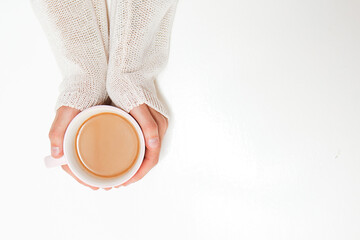 Female hands holding cups of coffee on white table background