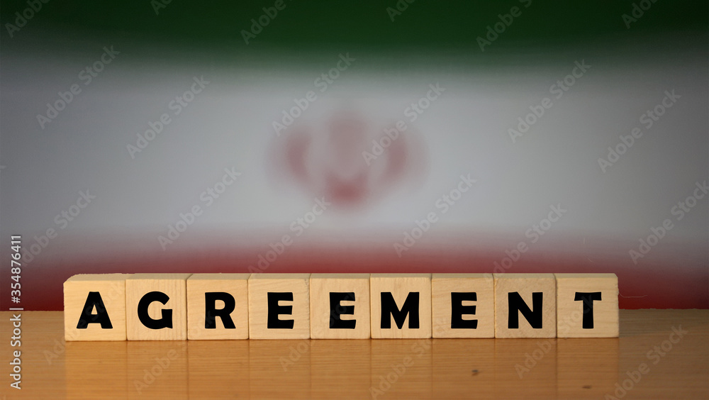 Poster agreement message word on a wooden desk on cube blocks with a iran flag background.