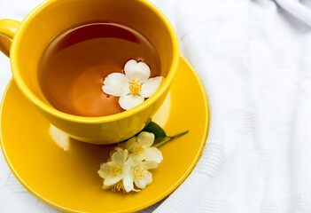 jasmine tea in a yellow cup. Healthy drink, diet or herbal medicine concept. Background, flower.
