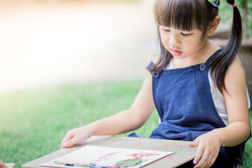 Close up background view Of cute girls drawing pictures for learning, artistic marketing concepts or studying during the semester outside the classroom