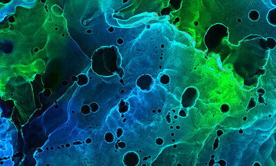 Dark deep indigo alcohol ink neon abstract background. Bright glowing flow blue liquid watercolor...