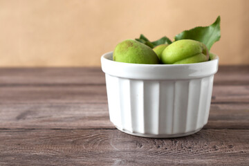 green unripe apricot fruits on wooden background, copy space, eco products