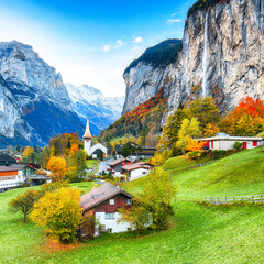Gorgeous autumn landscape of  alpine village Lauterbrunnen with famous church and Staubbach...