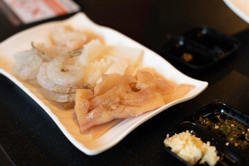 fresh seafood like squid,shrimp etc on white plate in restaurant