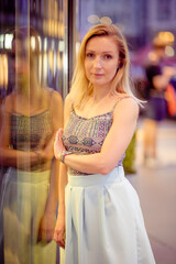 Young stylish beautiful woman walking in street, wearing dress and jacket, fashion outfit, spring and summer trend.