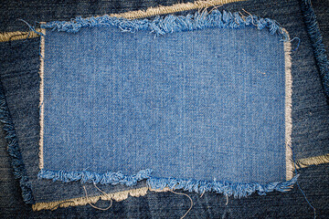 Destroyed torn denim blue jeans fabric frame on blue jeans background. Worn Jeans Casual Double...