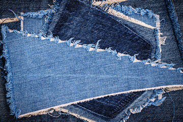 Destroyed torn denim blue jeans fabric frame on blue jeans background. Worn Jeans Casual Double...