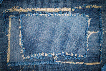 Destroyed torn denim blue jeans fabric frame on blue jeans background. Worn Jeans Casual Double...