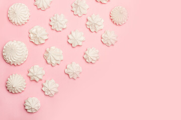 Malvaviscos merengue blancos en forma de rosa sobre un fondo rosa liso y aislado. Vista superior. Copy space
