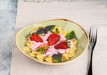 Pasta with strawberry cream and fresh strawberries and basil