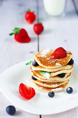 Pancakes with blueberries, strawberries and mint