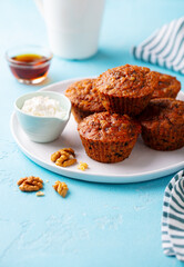 Healthy vegan carrot muffins with riccota cheese on a plate. Blue stone background.