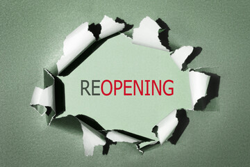 Reopening business, economy recovery after lockdown end concept. Word reopening on torn paper...