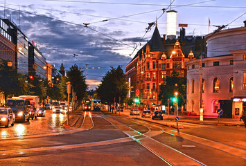 .helsinki night with classic old colorful buildings, street traffic, people walking an blue hour sky, finland
