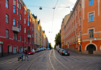 street with cars, people, colorful old buildings and architecture and cloudy blue sky in Helsinki, Finland