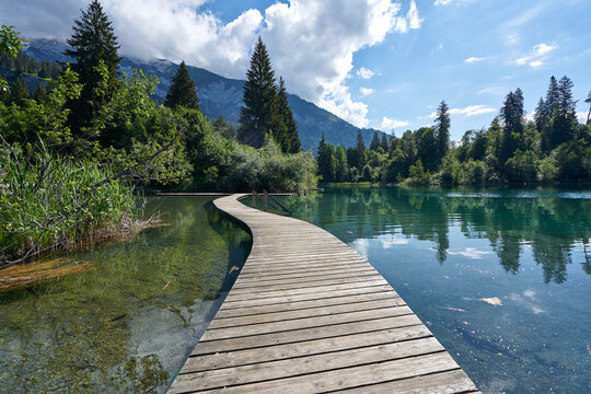 Landscape panorama of Crestasee - Lake Cresta in June, municipalities of Flims and Trin in the Grisons, Switzerland. Wooden dock on the lake.      