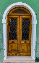 Old traditional door on colorful building at Burano island, Italy