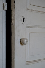 Details of a white painted wooden door of an empty abandoned old building