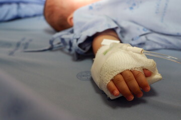 Children hand with saline solution in hospital.