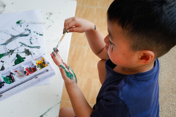 Funny little boy with painted hand