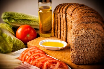 rebanadas de pan de molde integral con decoración de tomate lechuga aceite de oliva y fiambre 