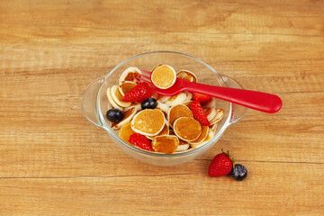 Tiny mini pancakes lie in a transparent glass bowl, decorated with blueberries and strawberries. Brunch, Breakfast for children