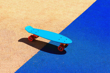 Photo of a blue skateboard against a two-color artificial surface background.Sports and recreation © денис климов