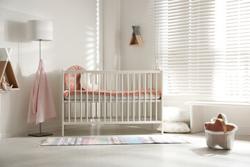 Cute baby room interior with crib and decor elements