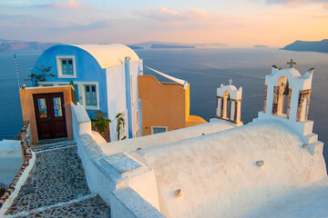 sunset view of typical white church and house in oia santorini