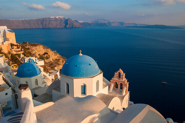 typical white church with blue dome in the city of oia in santorin