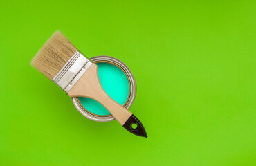 Home repairs, painting walls, furniture. Paint brush on an open jar with bright paint. Top view, free space for text.