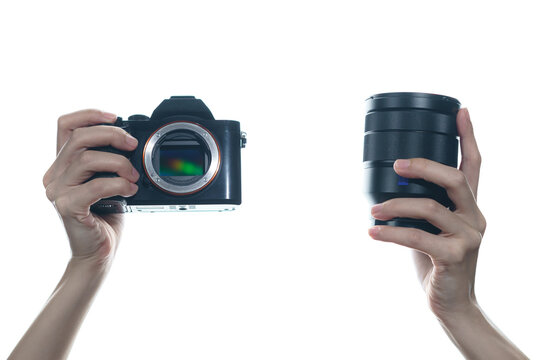 Woman hand holding camera and lens on white background.