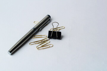 pen and paper clip on a white background