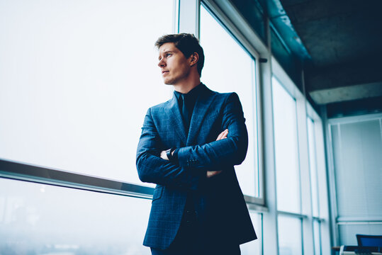 Caucasian male colleague in formal suit standing in office interior