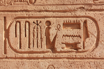 Ancient historical characters encased in a cartouche at a temple in Upper Egypt. It is the famous travel destination Abu Simbel on Lake Nasser. - obrazy, fototapety, plakaty