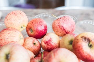 Beautiful fresh & organic colorful apples picked from the garden in a salad bowl on a marble table.