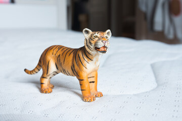 Beautiful miniature white and brown tiger made of rubber or plastic. Perfect for children to play with. Blurred background.