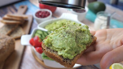 Peppering An Avocado Toast In A Hand.