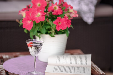 Obraz na płótnie Canvas Beautiful composition with glass of water with old book and flower on table close up