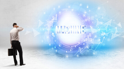 Rear view of a businessman standing in front of MACHINE inscription, modern technology concept