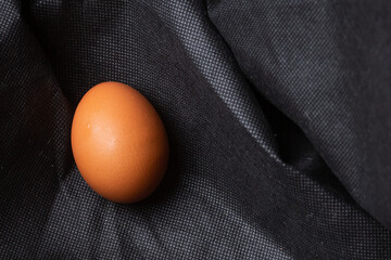 Egg on black fabric background