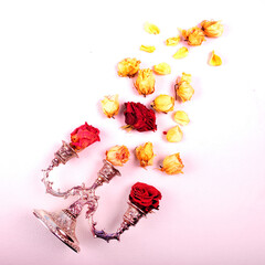 Square image of three armed silver candelabra. Faded roses and rose petals flying out of the candle holder.  Flat lay diagonal arrangement on white background.  