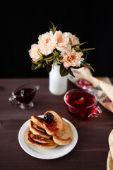 Obraz na płótnie Canvas Pancakes with jam. Photo of a glass of tea and pancakes.