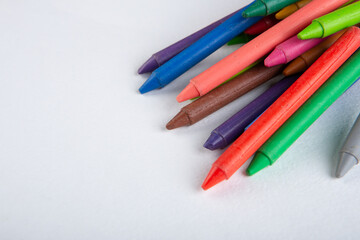 colored crayons and blank page on the wooden table