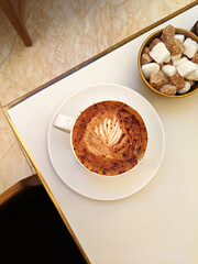 Flatlay View of Cappuccino with Barista Art on Cafe Table in London, UK