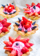 beautiful tasty cupcakes close up with strawberries, honeysuckle and pink cream