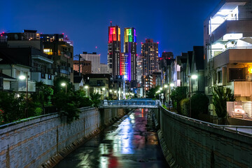 Fototapeta na wymiar 東京都庁 夜景 七色のライトアップ 神田川、花見橋から（中野区）
