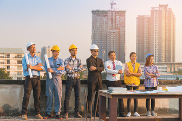 Engineer team showing unity by standing at construction site.