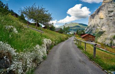 Fototapeta premium Road between mountain villages Mürren and Gimmelwald. Swiss Alps landscape photo with nature and snowy mountains taken above Lauterbrunnen valley, Switzerland. 